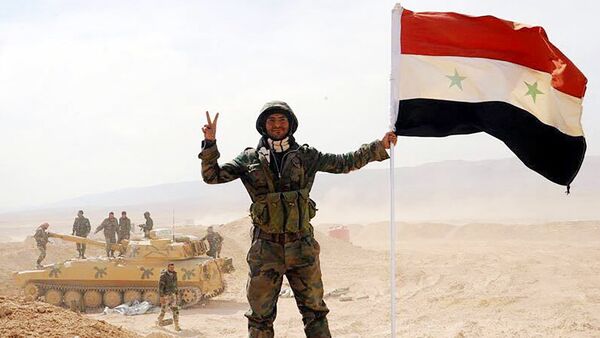 Soldado do exército sírio com a bandeira do país após o fim do cerco de Deir ez-Zor - Sputnik Brasil