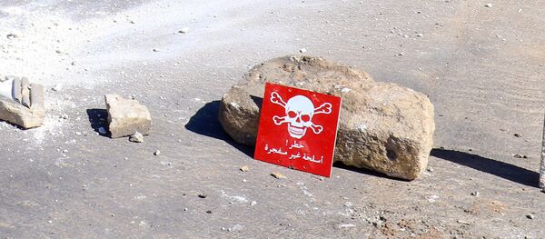 Men ride a motorbike past a hazard sign at a site hit by an airstrike on Tuesday in the town of Khan Sheikhoun in rebel-held Idlib, Syria April 5, 2017 - Sputnik Brasil