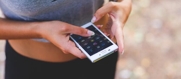 Uma mulher com celular - Sputnik Brasil