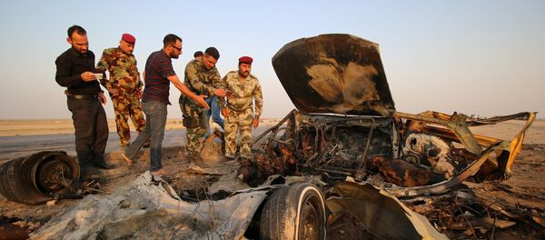 Forças de segurança do Iraque inspecionam o local de um ataque de um carro bomba em uma rodovia perto da cidade de Nassiriya, em 14 de setembro de 2017 - Sputnik Brasil
