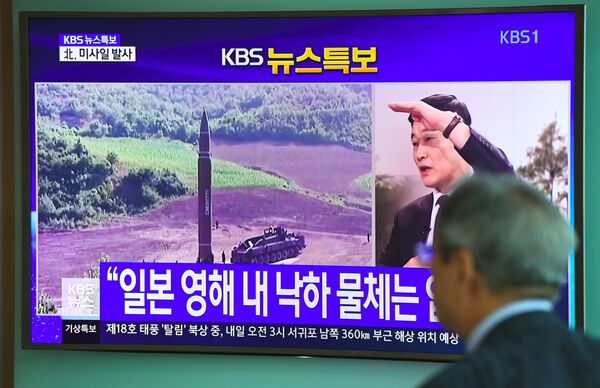 Homem assiste ao lançamento de míssil balístico disparado pela Coreia do Norte em 15 de setembro de 2017 Homem assiste ao lançamento de míssil balístico disparado pela Coreia do Norte em 15 de setembro de 2017 - Sputnik Brasil