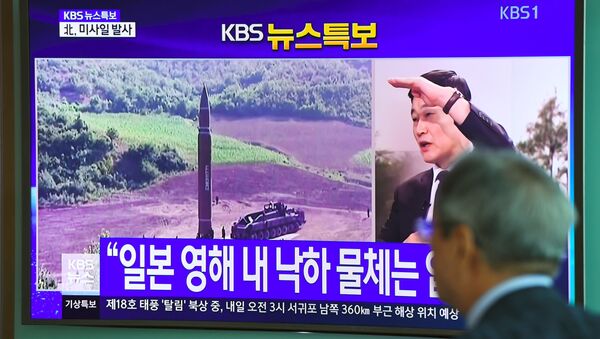 Homem assiste ao lançamento de míssil balístico disparado pela Coreia do Norte em 15 de setembro de 2017 - Sputnik Brasil