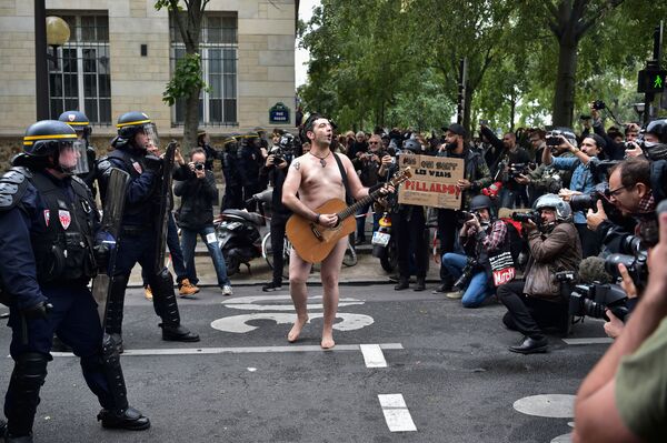 Homem nu toca violão em frente dos policiais durante um protesto convocado pelos sindicados franceses contra a reforma trabalhista proposta pelo presidente Emmanuel Macron, em Paris - Sputnik Brasil