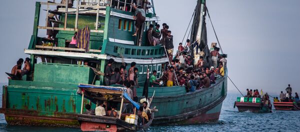 In this photo taken on May 20, 2015 shows Rohingya migrants resting on a boat off the coast near Kuala Simpang Tiga in Indonesia's East Aceh district of Aceh province before being rescued. Indonesia's foreign minister demanded answers from Canberra about claims Australian officials paid thousands of dollars to turn a boat back to Indonesia after Prime Minister Tony Abbott refused to deny the allegations - Sputnik Brasil