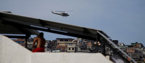 A military helicopter flies overhead during an operation after violent clashes between drug gangs in Rocinha slum in Rio de Janeiro, Brazil - Sputnik Brasil