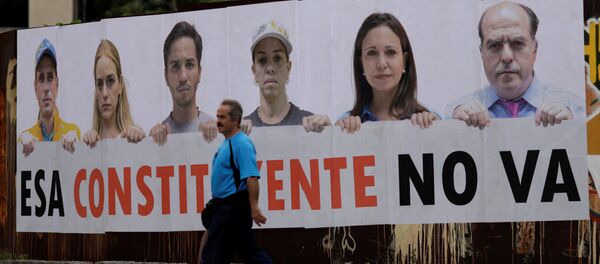 Um homem atravessa um anúncio que diz: A Assembleia Constituinte não acontecerá, em Caracas, Venezuela, 24 de julho de 2017. Destacam-se na peça: Henrique Capriles, líder da oposição venezuelana e governador de Miranda, Lilian Tintori esposa do líder da oposição Leopoldo López, Julio Borges, presidente da Assembleia Nacional e legislador da coalizão venezuelana de partidos de oposição (MUD) e a líder da oposição, Maria Corina Machado. - Sputnik Brasil