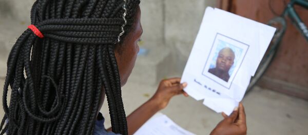 Jacquendia Cangé segura a foto do policial nigeriano da ONU, que ela alega a ter estuprado: 'Nunca vou conseguir perdoar', afirma - Sputnik Brasil