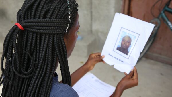 Jacquendia Cangé segura a foto do policial nigeriano da ONU, que ela alega a ter estuprado: 'Nunca vou conseguir perdoar', afirma - Sputnik Brasil