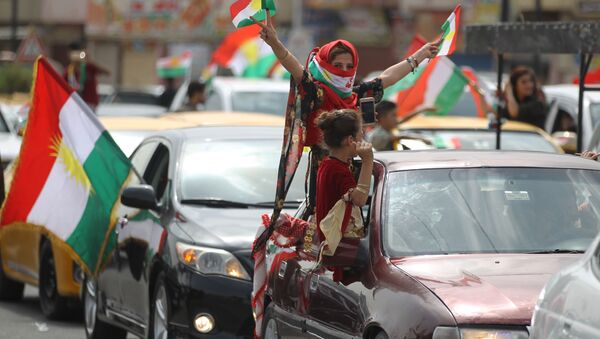 Curda iraquiana com a bandeira mostrando gesto de vitória durante as celebrações em Kirkuk - Sputnik Brasil
