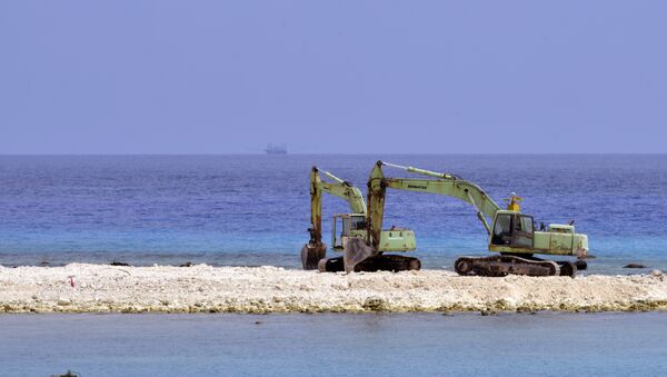 Duas escavadeiras durante a construção na ilha de Taiping island no Mar da China Meridional em 23 de março de 2016 - Sputnik Brasil