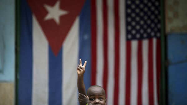 Eric, de 3 anos, posa para foto em frente às bandeiras de Cuba em EUA em Havana. - Sputnik Brasil
