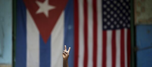 Eric, 3, gestures while posing for a photograph in front of the Cuban and U.S. flags in Havana, March 25, 2016. - Sputnik Brasil