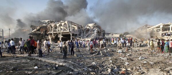 Somalis gather and search for survivors by destroyed buildings at the scene of a blast in the capital Mogadishu, Somalia, Saturday, Oct. 14, 2017 - Sputnik Brasil
