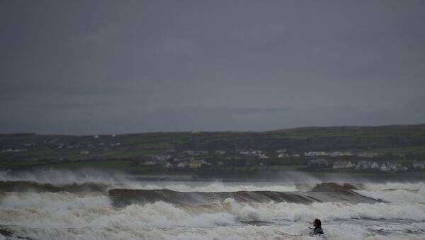 Surfista nada no oceano Atlântico na véspera da chegada do furacão Ophelia, Irlanda, 15 de outubro de 2017 - Sputnik Brasil