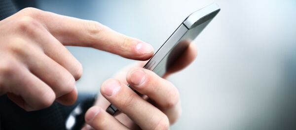 Homem segurando um smartphone (imagem referencial) - Sputnik Brasil