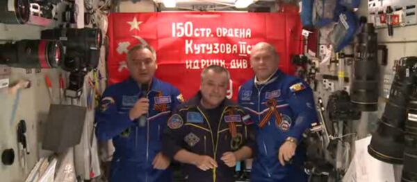 Bandeira da vitória com os cosmonautas russos na ISS. Bandeira da vitória com os cosmonautas russos na ISS. - Sputnik Brasil