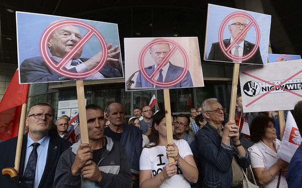 Manifestantes, fora do escritório do líder Jaroslaw Kaczynski, segurando bandeiras com imagens do empresário George Soros, do presidente do Conselho Europeu Donald Tusk e do primeiro vice-presidente da Comissão Européia, Frans Timmermans, durante um protesto em Varsóvia, em 26 de julho de 2017 - Sputnik Brasil