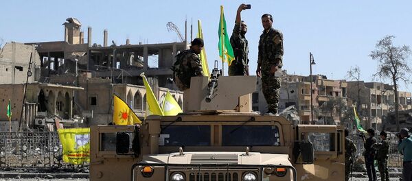 Militante das Forças Democráticas da Síria tira selfie sobre veículo militar em Raqqa - Sputnik Brasil