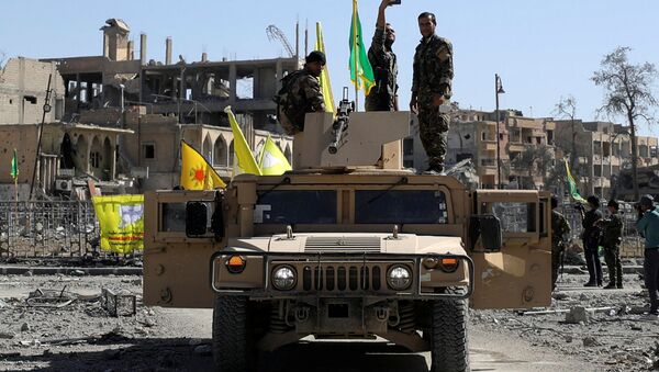 Militante das Forças Democráticas da Síria tira selfie sobre veículo militar em Raqqa - Sputnik Brasil