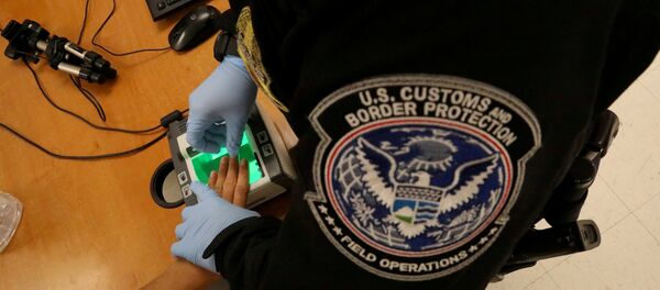 Uma mulher que está buscando asilo tem suas impressões digitais tomadas por um oficial de fronteira dos EUA. - Sputnik Brasil