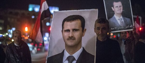 Жители Дамаска держат портреты сирийского президента Башара Асада во время встречи военнослужащих Сирийской арабской армии, участвовавших в снятии блокады с авиабазы Квейрис в провинции Алеппо - Sputnik Brasil