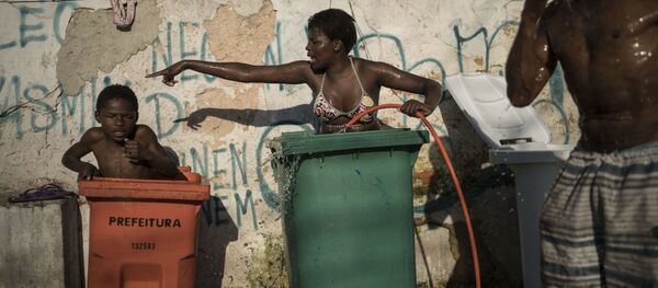 Mulher e criança tomam banho em contentores para lixo na favela da Mangueira, Rio de Janeiro - Sputnik Brasil
