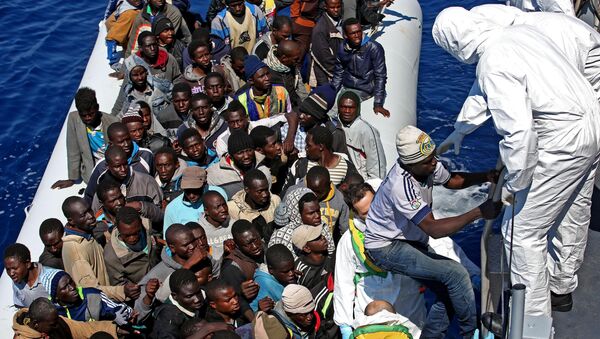 Guarda Costeira italiana se aproxima de barco de imigrantes na costa da Líbia, no Mar Mediterrâneo, em 22 de abril de 2015 - Sputnik Brasil