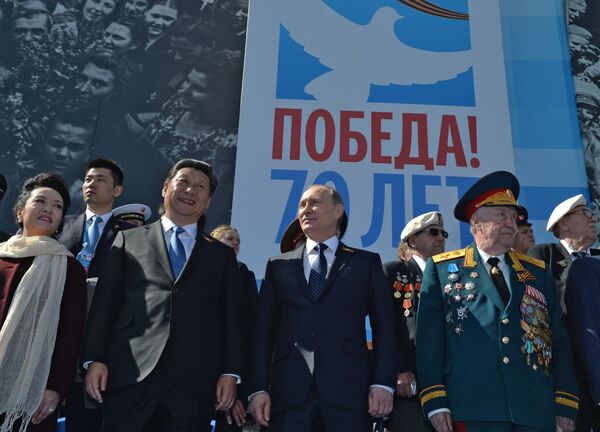 Vladimir Putin (centro) e Xi Jinping (esquerda, com a esposa, Peng Liyuan), durante a Parada da Vitória em Moscou, em 9 de maio de 2015 - Sputnik Brasil