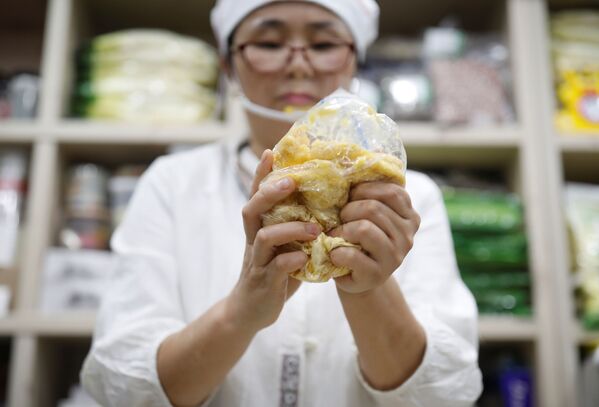 A desertora norte-coreana Hong Eun-hye demonstra como o seu povo prepara bolos de arroz com farinha de milho dentro da sua loja de comida norte-coreana em Seul, na Coreia do Sul - Sputnik Brasil
