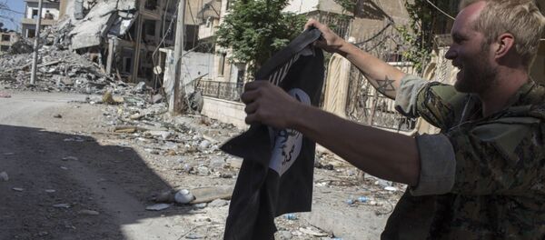 Soldado segurando bandeira do Daesh em Raqqa, Síria - Sputnik Brasil