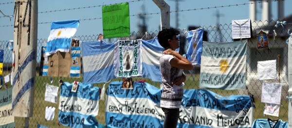 Mulher olhando para mensagens e sinais de apoio aos 44 tripulantes do submarino perdido ARA San Juan - Sputnik Brasil
