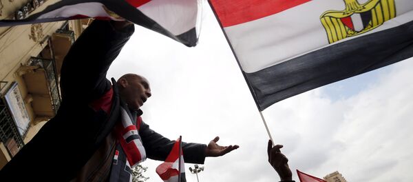 Pro-government protesters chant slogans while holding the national flag during the fifth anniversary of the uprising that ended 30-year reign of Hosni Mubarak in Cairo, Egypt, January 25, 2016 - Sputnik Brasil