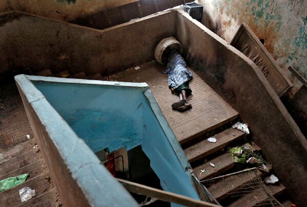 Mendigo dorme em escada em um dos mercados de Bengaluru, Índia - Sputnik Brasil